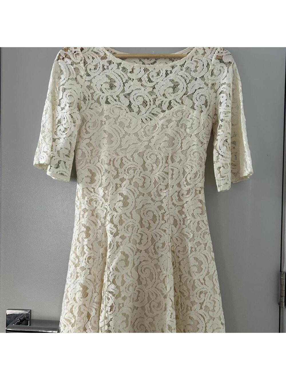 Free People cream lace dress with short sleeves and a flared skirt